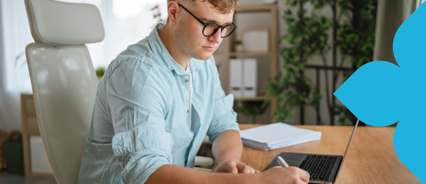 ​Estudiante de ciencias sociales en clase virtual toma apuntes en su libreta​