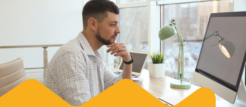 Hombre senior estudiante de Mercadeo revisa su computador