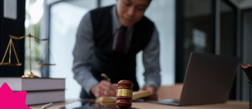 Un abogado de rasgos asiáticos en su despacho escribe en su libreta